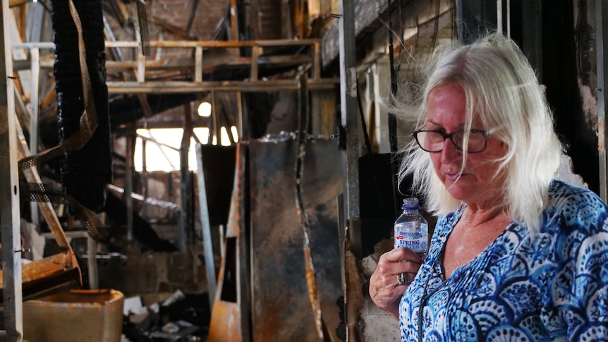 A woman at the site of a house fire.