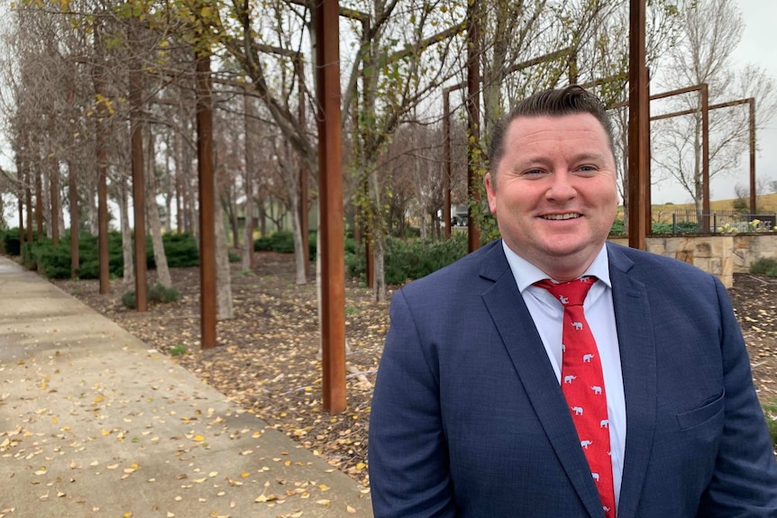 Nathaniel Smith smiling standing in front of the entrance to Bingara Gorge housing estate near Picton.