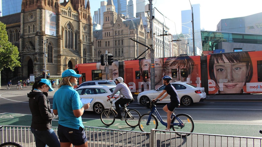 Two woman count the number of passing cyclists.