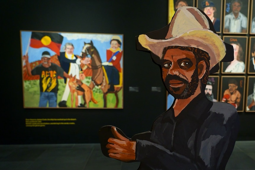 A double-sided portrait of Vincent on plywood standing up in front of other artworks