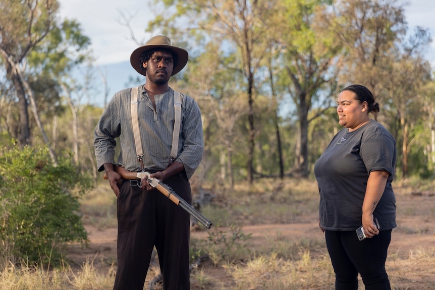 Andrew Young, dressed in character and holding a rifle, with producer Lelarnie Hatfield-Yasso