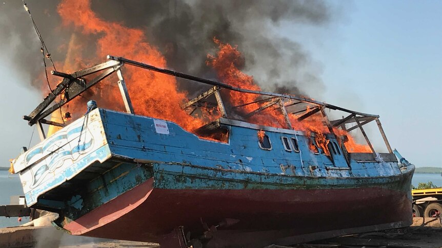 a wooden fishing vessel being burnt.
