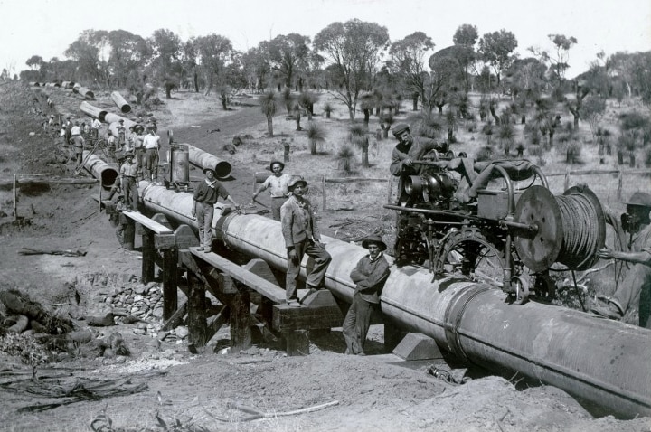 An historic photograph of a water pipeline being built.