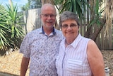 Dr Neil Wetzig and his wife Gwen Wetzig smile as they stand together in a garden in Brisbane.