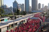 People begin to flow over Brisbane's Victoria Bridge for the International Women's Day fun run