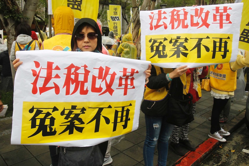 Protesters hold slogans reading "Tax Reform. No more Miscarriage of Justice" outside of Ministry of Finance in Taipei, Taiwan.