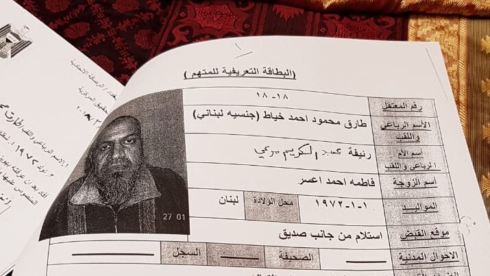A photograph of a page showing a man's photograph and text in Arabic.