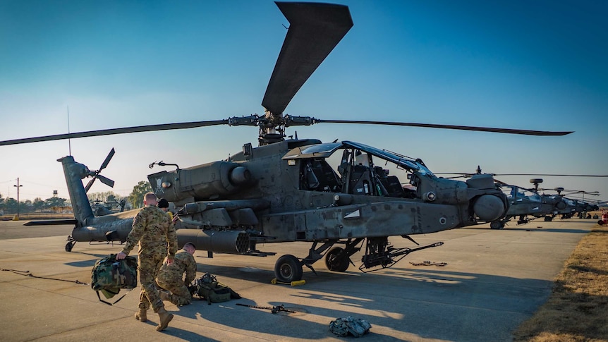 Apache helicopters lined up.