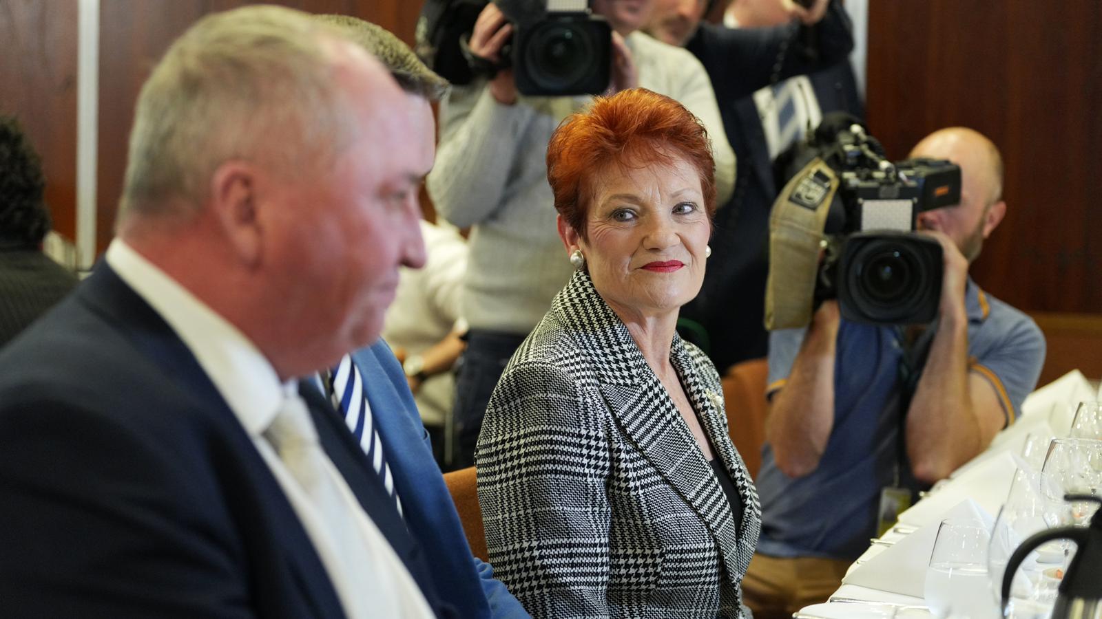 pauline smiles at her colleagues a cameraman films in the background
