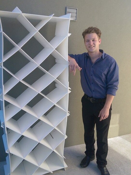 Lincoln Williams standing next to an assembled disposable bed in Hobart.
