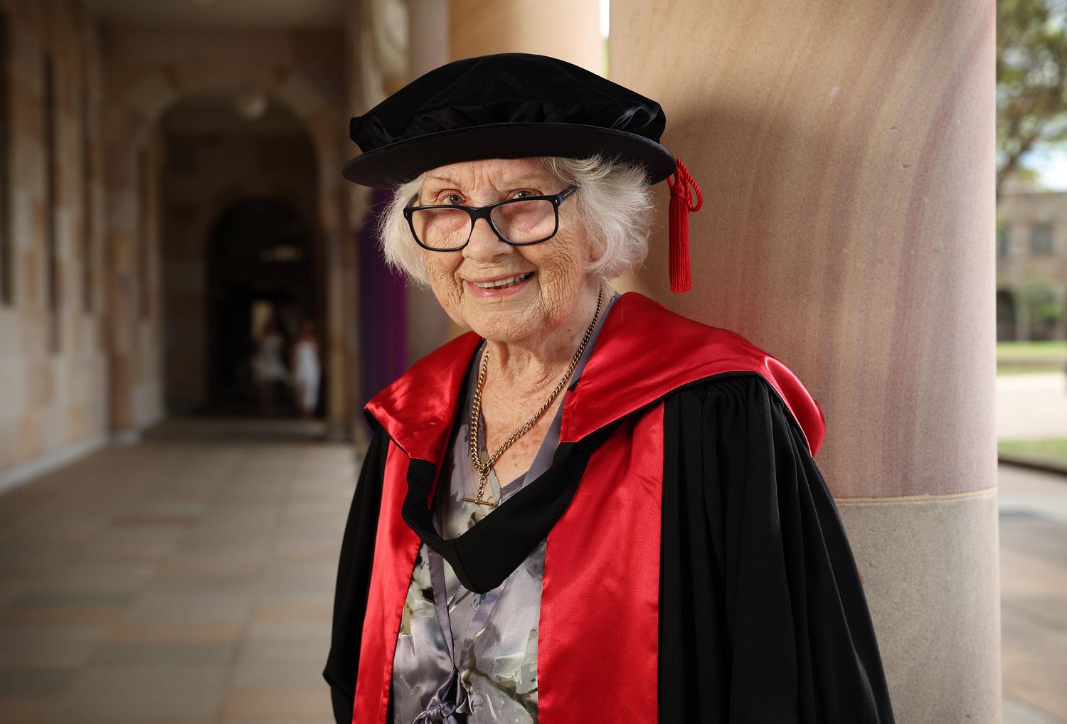 An elderly woman with a degree hat and gown on