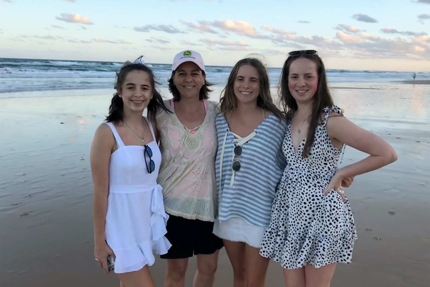 Deb Frecklington standing with her three daughters on a beach