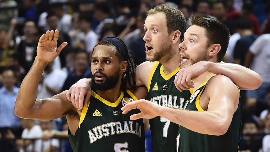 Three basketballers watch the play intently during a FIBA World Cup game.