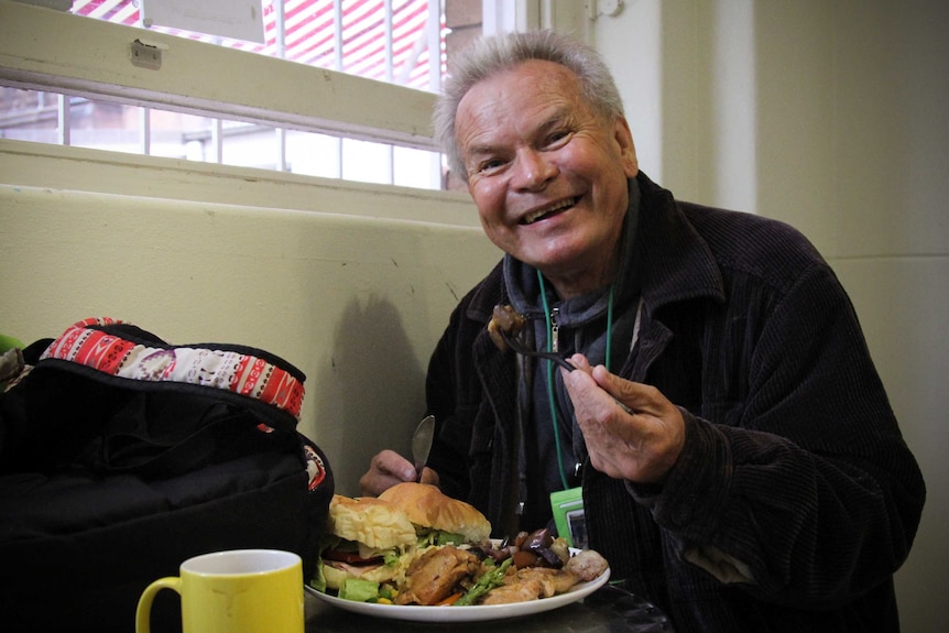 A man holding up a forkful of food.