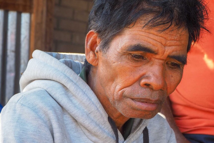 An older East Timorese man looking thoughtful