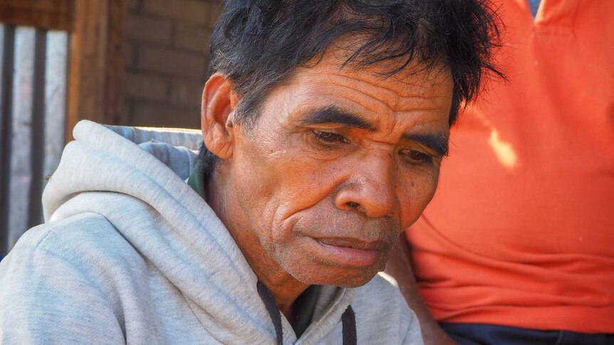 An older East Timorese man looking thoughtful