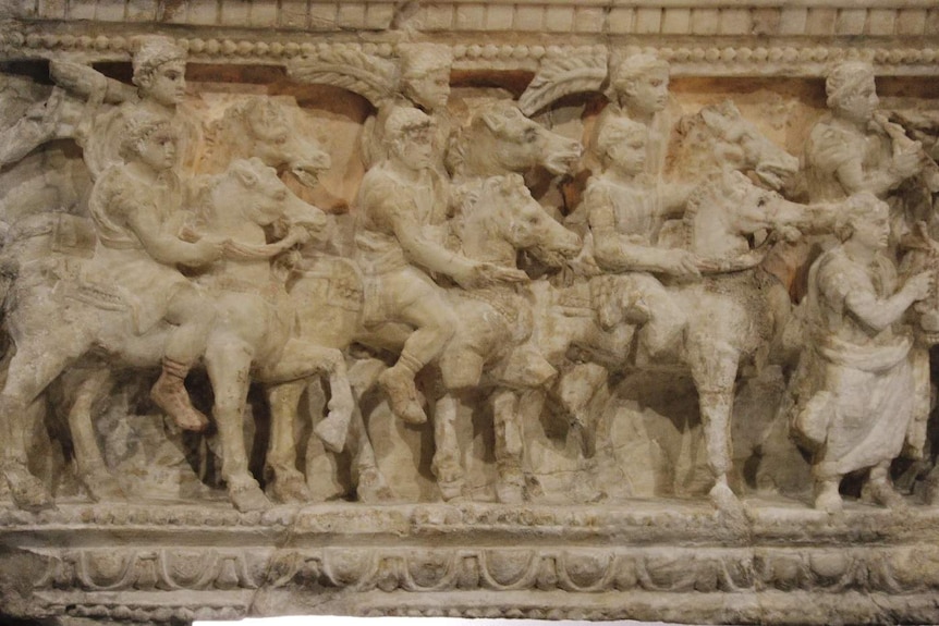 A close-up shot of embellishments on an ancient Roman urn.