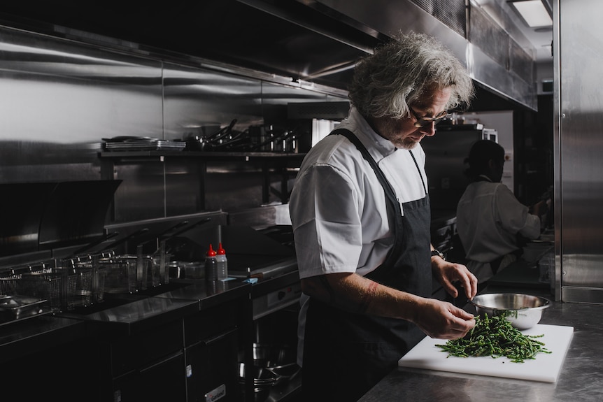 Chef Vince Trim preparing food in a commercial kitchen.