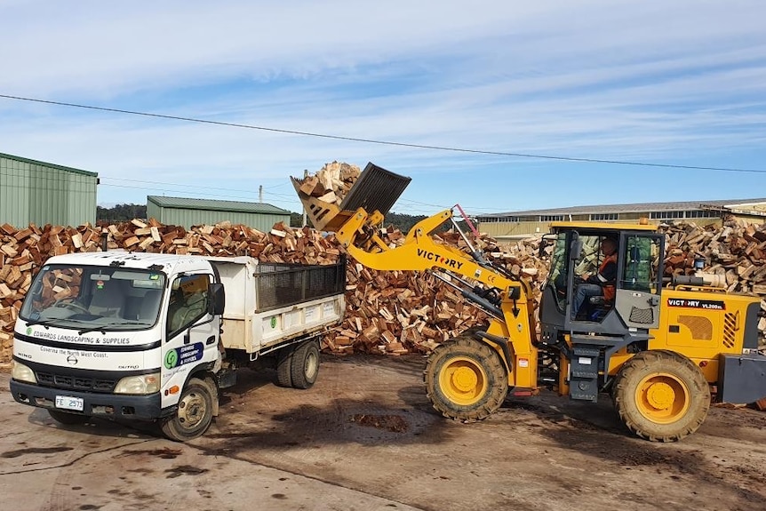 A truck loading firewood.