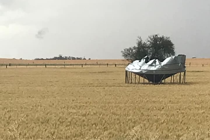 A grain field with a field bin destroyed by severe weather.
