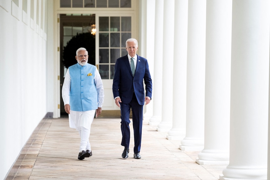 India’s Prime Minister Narendra Modi walks with US President Joe Biden. 