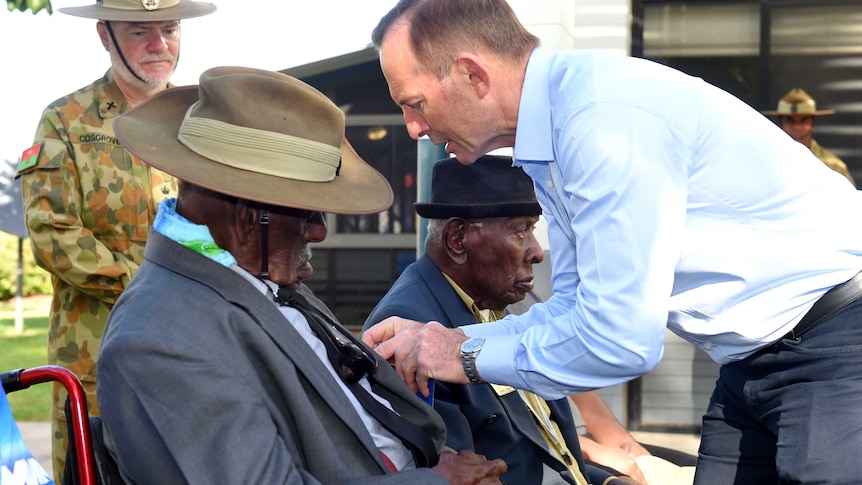 Prime Minister Tony Abbott presents a medal to Torres Strait veteran Bamia Mast