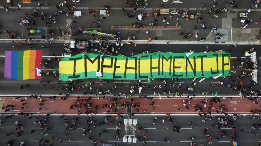 Vista aérea de un letrero que dice 'juicio político a Jair' sobre los colores nacionales de Brasil 