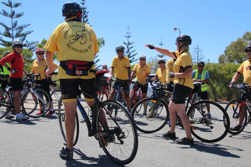 A group of cyclists gather with bright yellow shirts