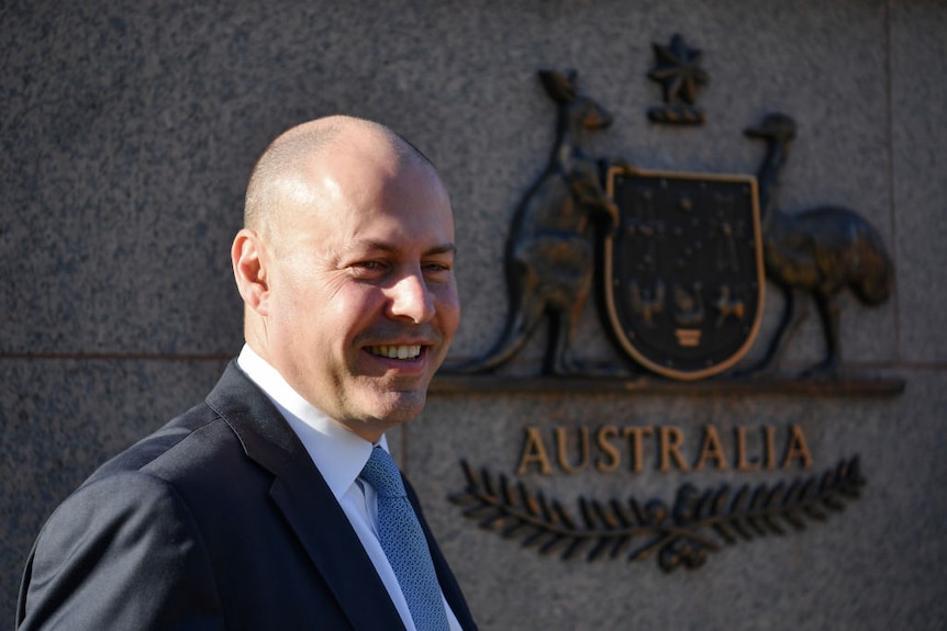 A smiling Treasurer, Josh Frydenberg, outside the Treasury Building