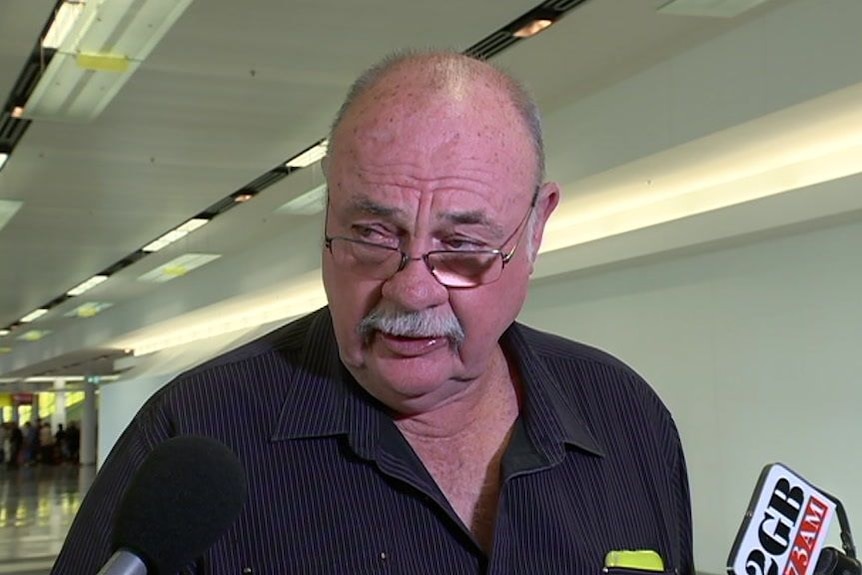 An older, moustachioed gentleman – Warren Entsch – wearing spectacles and a dark shirt.