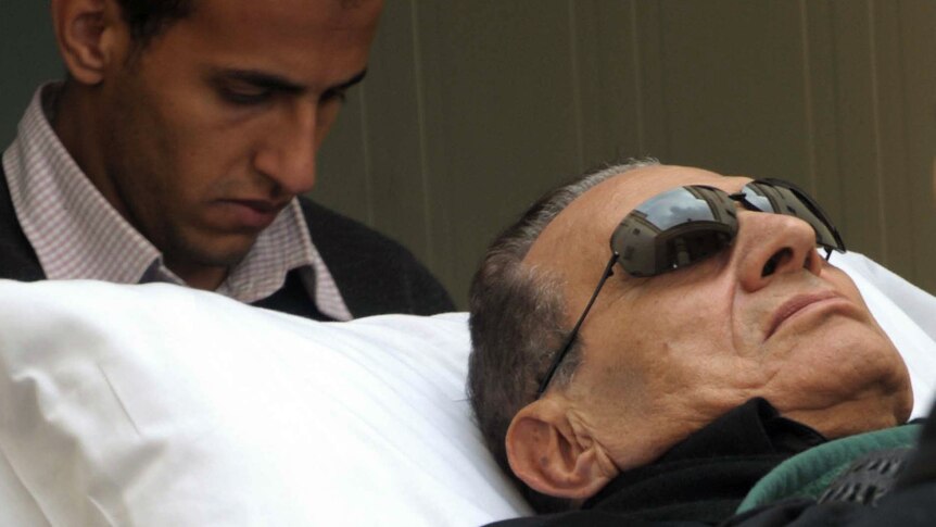 Ousted Egyptian President Hosni Mubarak is wheeled on a stretcher into court for his murder trial