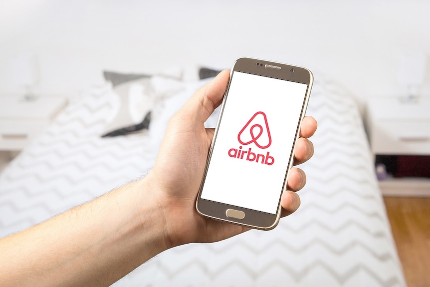 Airbnb app in a hand.