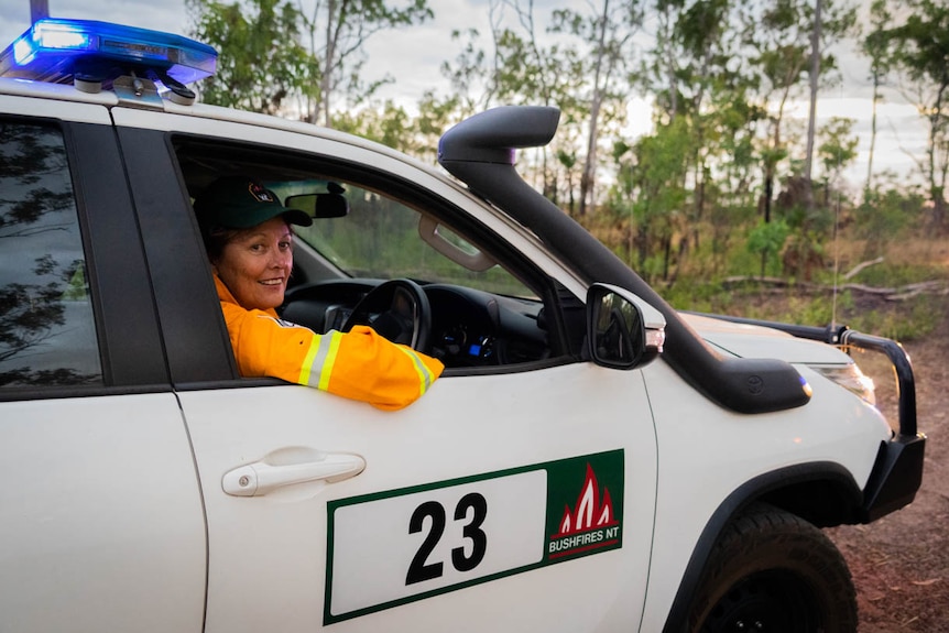 A photo of a female firefighter in a car