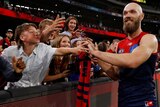 Max Gawn smiles as he high-fives some Melbourne supporters over the fence
