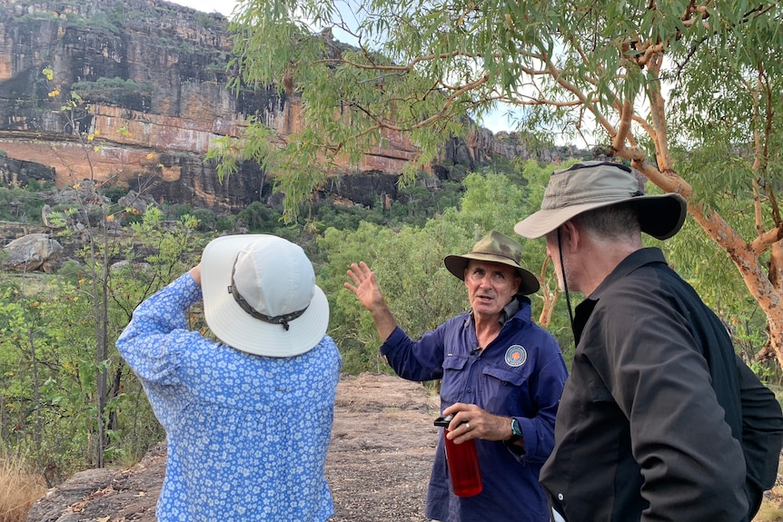 Greig Taylor guides a tour with two people at Nourlangie rock in Kakadu.