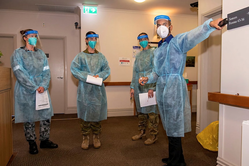 Three ADF personnel at an aged-care facility with a registered nurse.