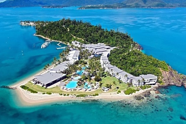 a picturesque island resort with white sand and blue waters, taken from above