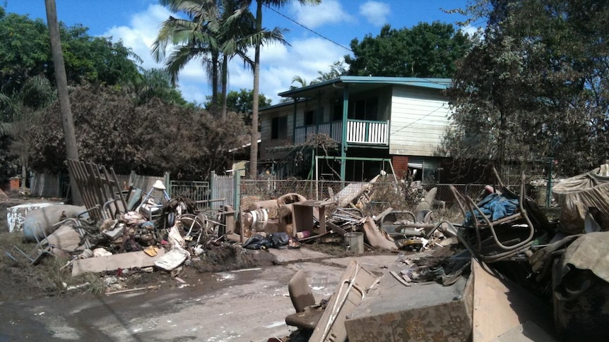 Household goods and debris scatter a flood-affected street