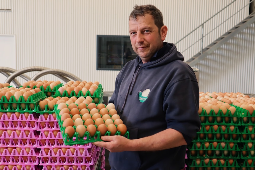 Man holding egg tray.