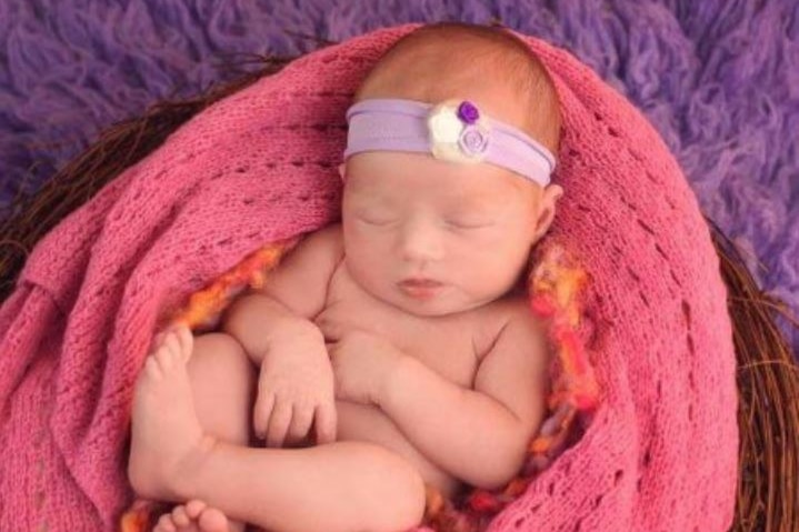 Baby Isabella asleep in a pink blanket.
