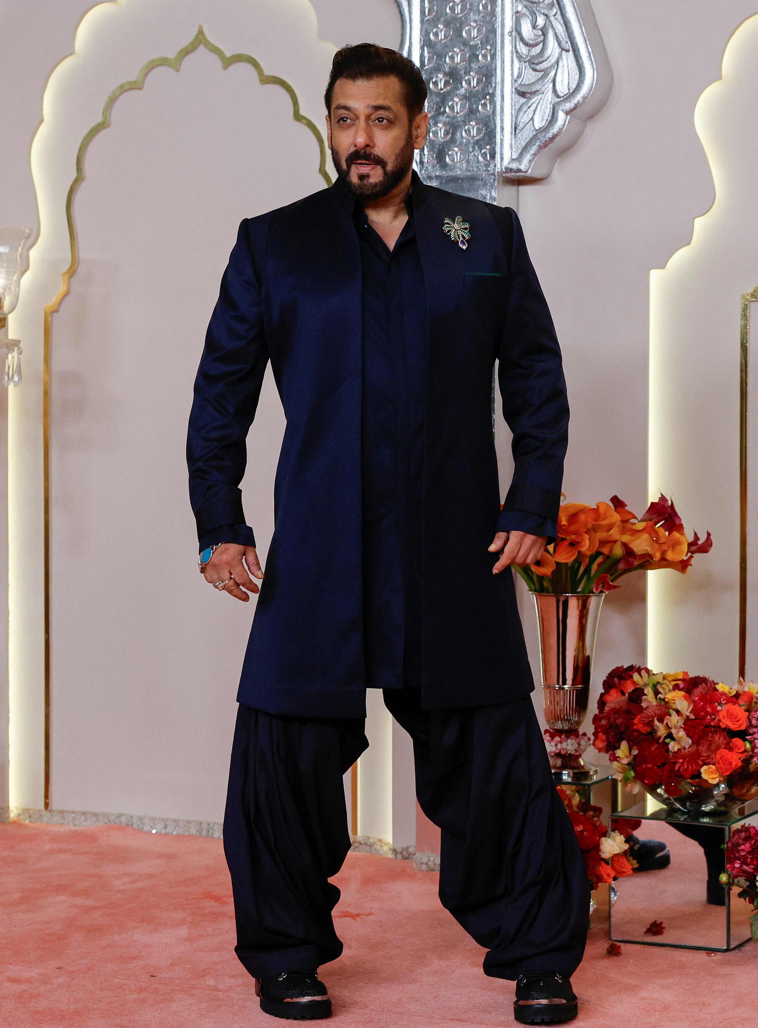 Salman Khan wearing a dark navy blue suit with a silvery brooch on his chest