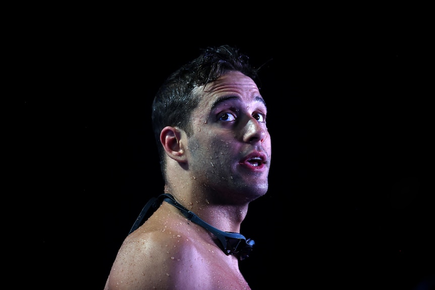 Swimmer Chad Le Clos looks skyward with his goggles around his neck, after exiting the pool.