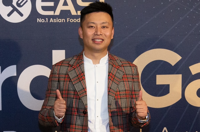 EASI CEO Jie Shen smiles with a blue background.