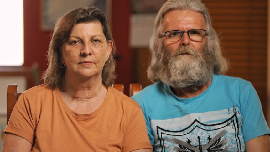 a man and a woman stare at the camera