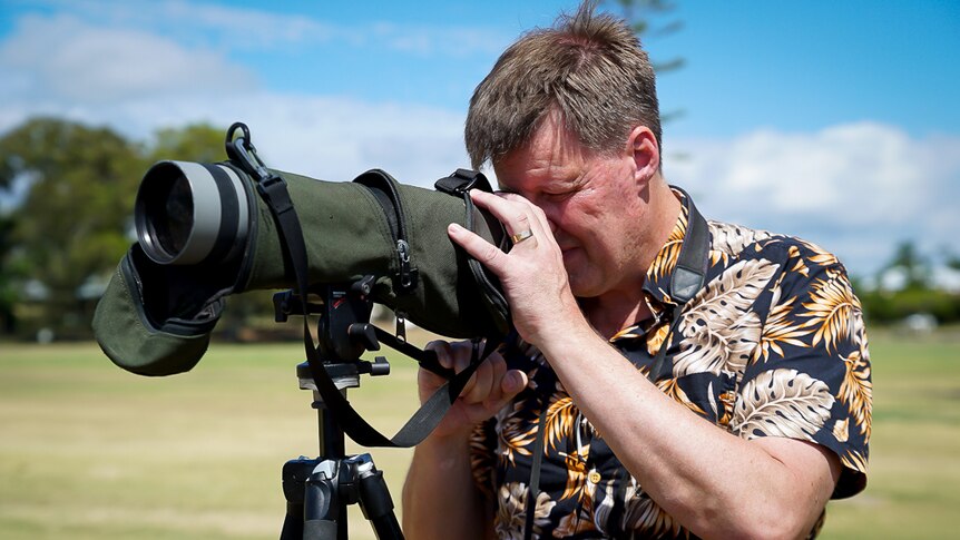 Robert Clemens looks through a large telescope.