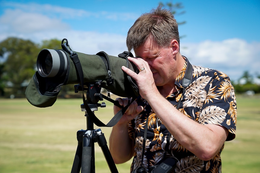 Robert Clemens looks through a large telescope.