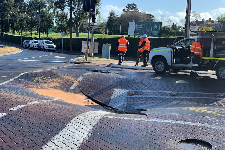 A hole in a road caused by water damage