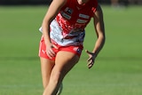 Meg Ryan leaning over to get the football in a match against Sturt in the SANFLW
