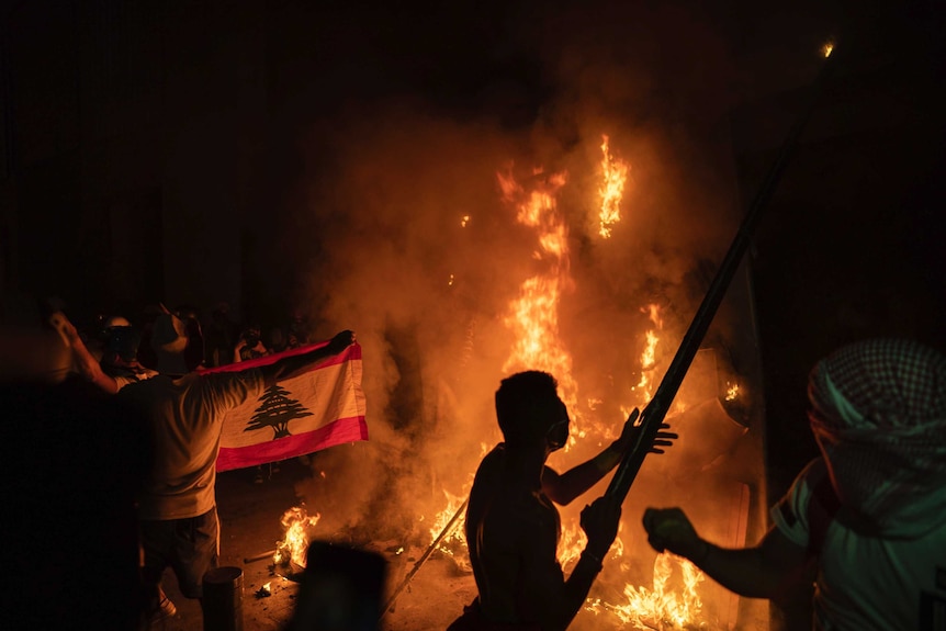 Anti-government protesters burn a barricade next to a wall near the Parliament in Beirut.