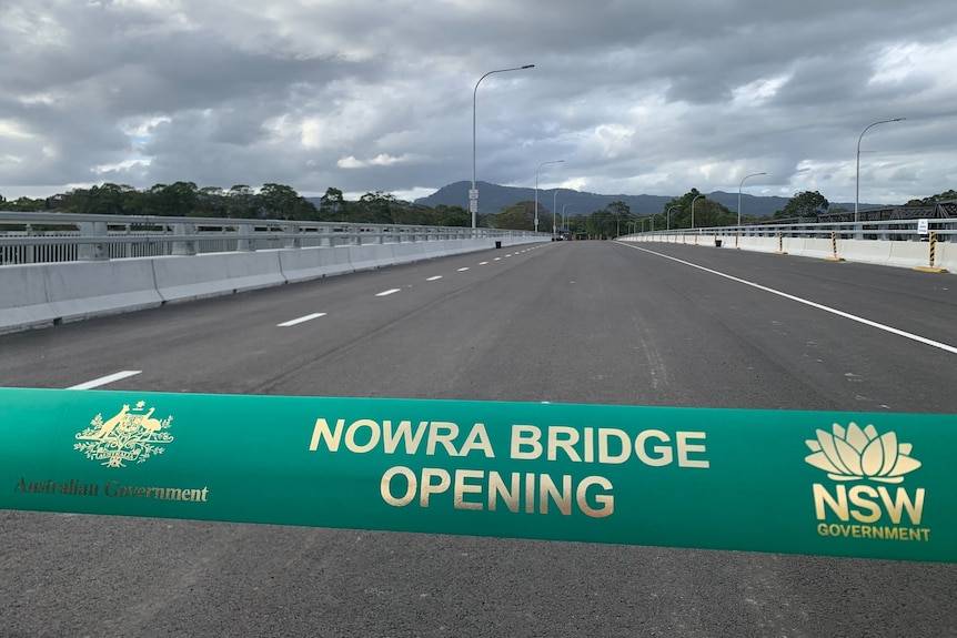 A green ribbon with Nowra Bridge Opening written on it with the bridge in the background.